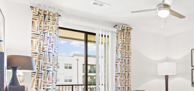 Northside at the Woodlands Living Room with Private Balcony a living room with a couch and a door to a balcony